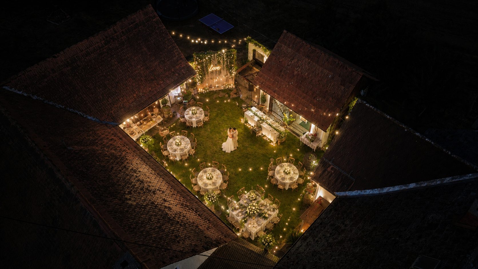 Hochzeitsdinner unter Lichterketten, Luftaufnahme bei Nacht